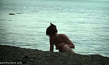 Gadis langsing menunjukkan tubuhnya yang telanjang di pantai yang nudis
