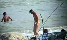 Mujer sin camisa muestra sus tetas en una playa nudista